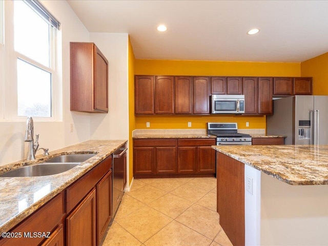 kitchen featuring light tile patterned floors, light stone counters, stainless steel appliances, a sink, and recessed lighting