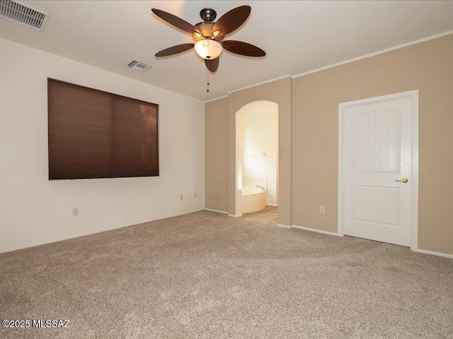 10590 E Maldonado Pl, Tucson, AZ 85747 - unfurnished bedroom with carpet flooring, arched walkways, ensuite bathroom, ceiling fan, and crown molding