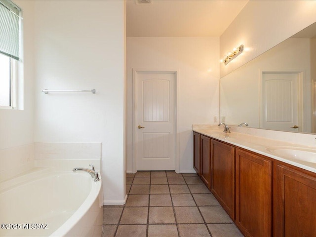 bathroom featuring a sink, double vanity, a garden tub, and tile patterned floors