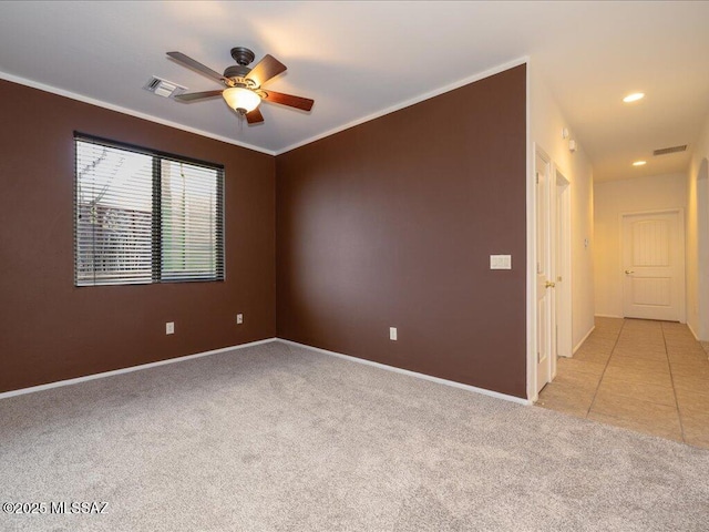 empty room featuring ornamental molding, light colored carpet, and visible vents