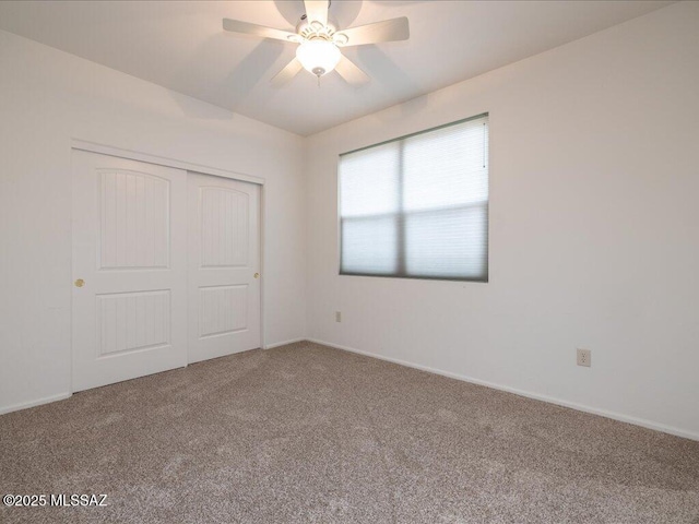 unfurnished bedroom with a ceiling fan, a closet, carpet flooring, and baseboards