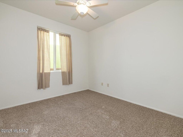 carpeted spare room with a ceiling fan