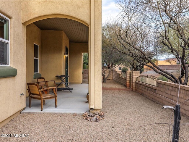 view of patio featuring a gate and fence