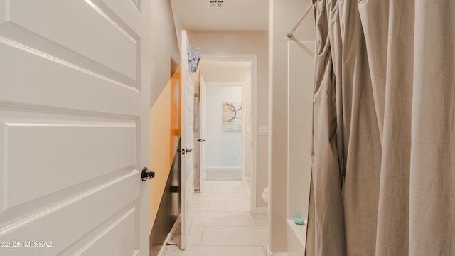 hallway featuring tile patterned flooring and visible vents