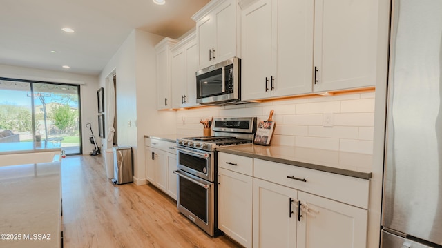 kitchen with light wood-style flooring, recessed lighting, stainless steel appliances, white cabinetry, and tasteful backsplash