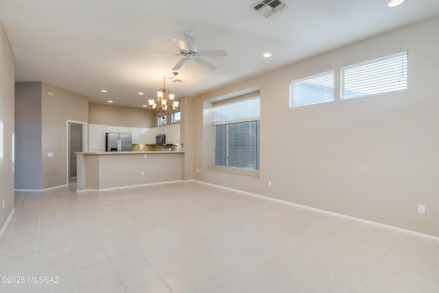 unfurnished living room featuring ceiling fan with notable chandelier, recessed lighting, visible vents, and baseboards