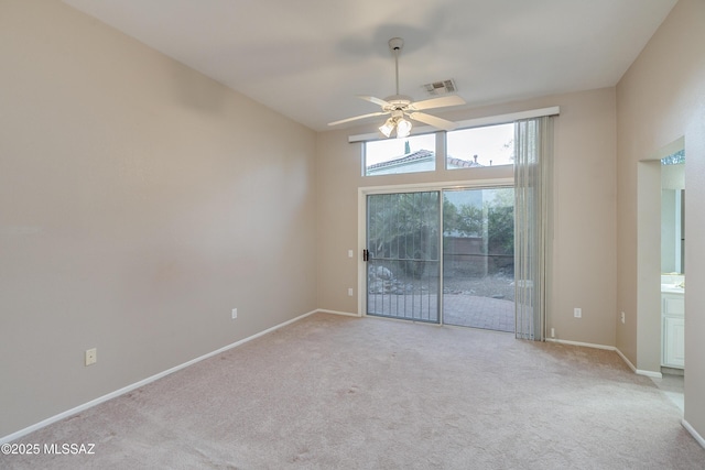 carpeted empty room featuring ceiling fan, visible vents, and baseboards