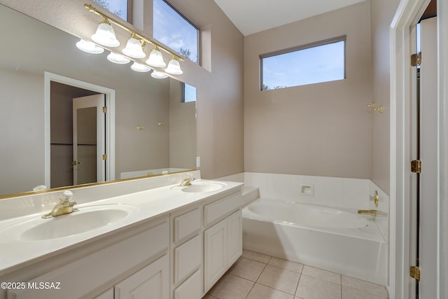 bathroom with double vanity, a sink, a bath, and tile patterned floors