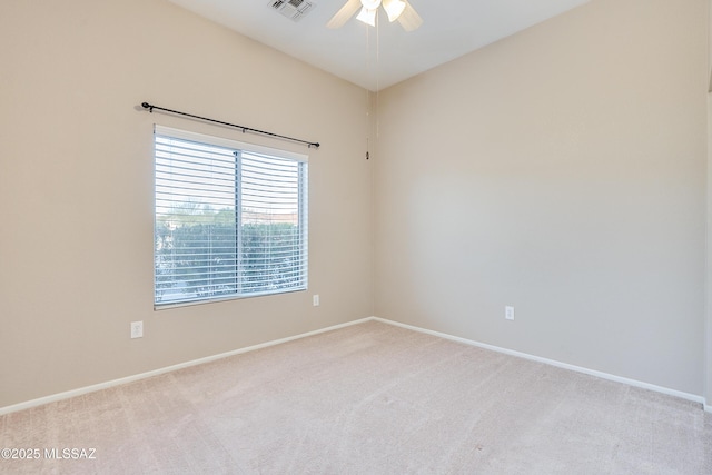 spare room with a ceiling fan, visible vents, light carpet, and baseboards