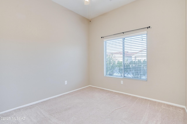 empty room featuring ceiling fan, baseboards, and light colored carpet