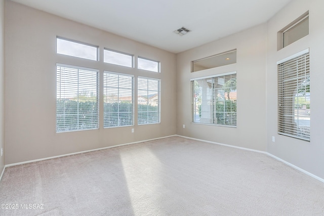 carpeted spare room with baseboards and visible vents