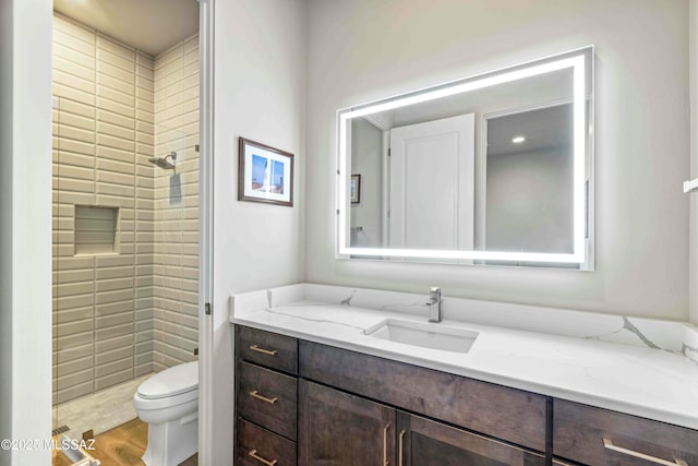 bathroom with toilet, a shower stall, vanity, and wood finished floors