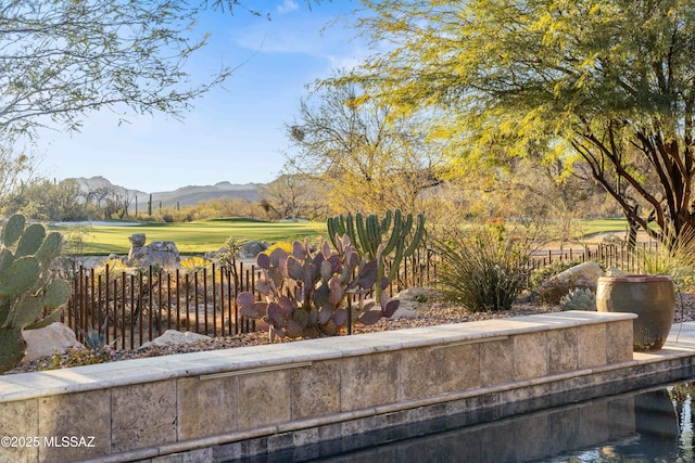 view of community featuring a yard, fence, and a mountain view