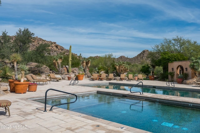 community pool featuring a mountain view and a patio