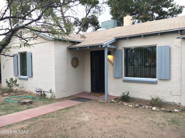 2031 E Silver St, Tucson, AZ 85719 - entrance to property with brick siding, roof with shingles, and a chimney