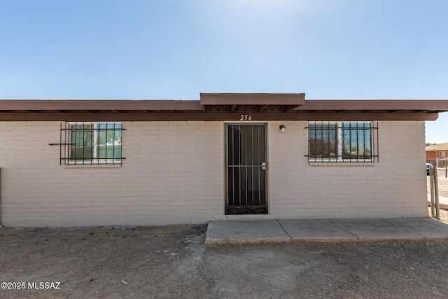 doorway to property with brick siding