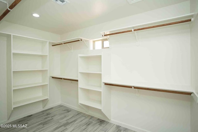 walk in closet featuring visible vents and wood finished floors