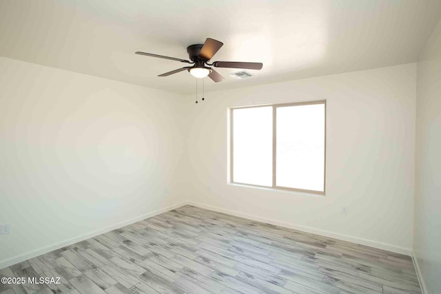 empty room featuring light wood-style floors, visible vents, ceiling fan, and baseboards