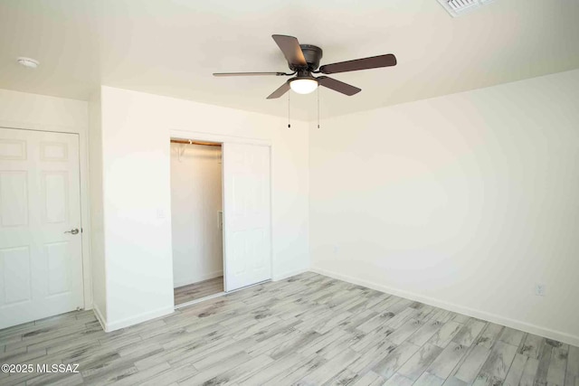 unfurnished bedroom with ceiling fan, a closet, wood finished floors, and baseboards