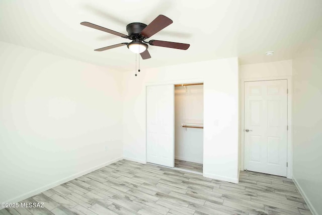 unfurnished bedroom with a ceiling fan, a closet, baseboards, and wood finished floors