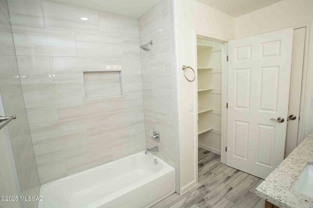 bathroom with double vanity, wood finished floors, a sink, and toilet