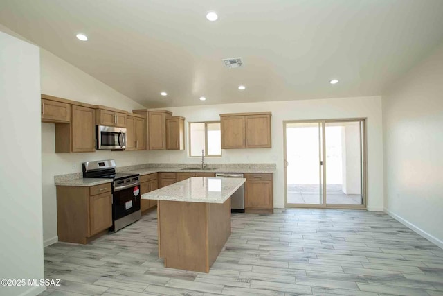 kitchen with lofted ceiling, a center island, stainless steel appliances, a sink, and recessed lighting