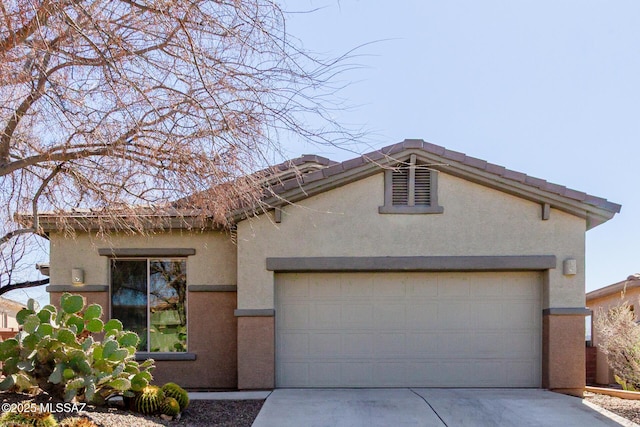 view of front of home with a garage, concrete driveway, and stucco siding