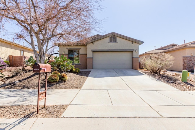 view of front of home with concrete driveway, an attached garage, a tiled roof, and stucco siding