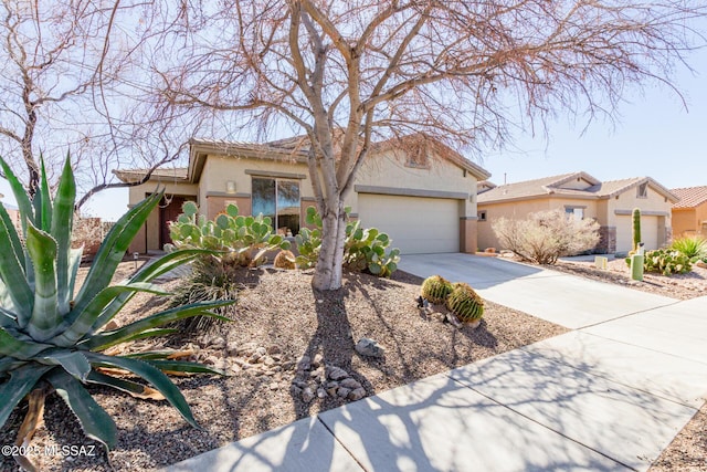 view of front of property featuring driveway, an attached garage, and stucco siding