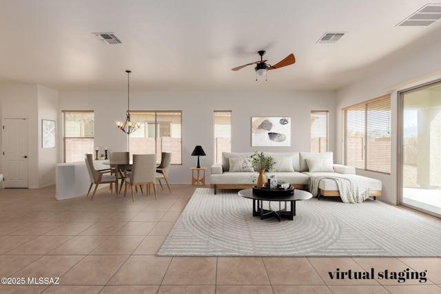 living area with ceiling fan with notable chandelier, visible vents, and light tile patterned flooring