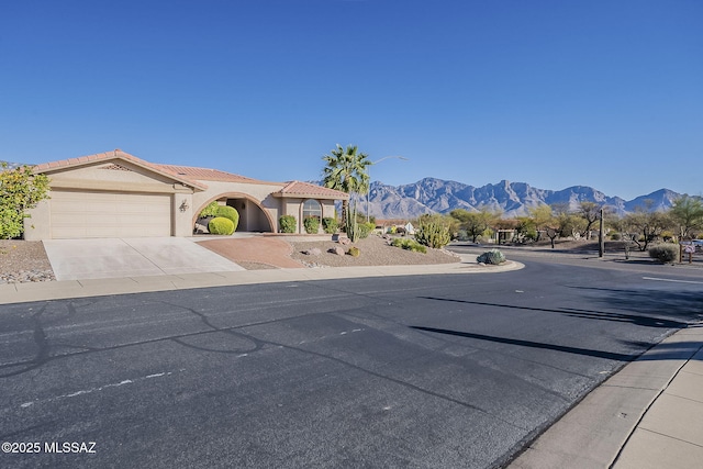 view of street featuring curbs, street lighting, sidewalks, and a mountain view