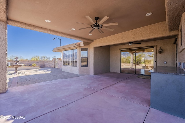 view of patio featuring fence and a ceiling fan