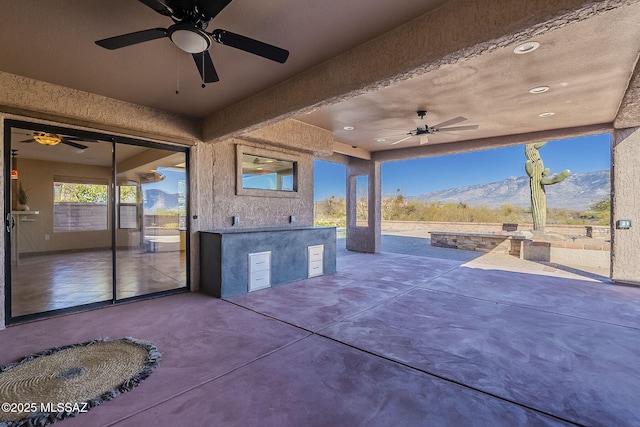 view of patio featuring ceiling fan, a mountain view, and area for grilling