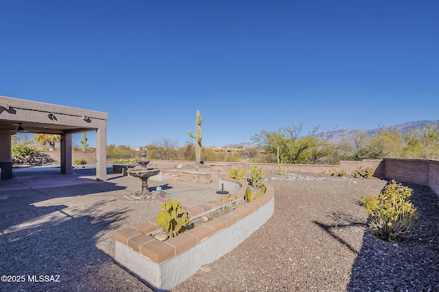 view of yard with a patio area, fence, and a mountain view