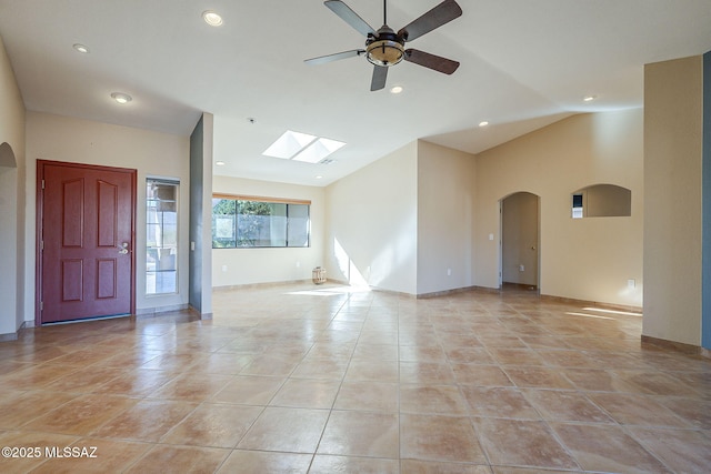 empty room featuring lofted ceiling, arched walkways, and recessed lighting