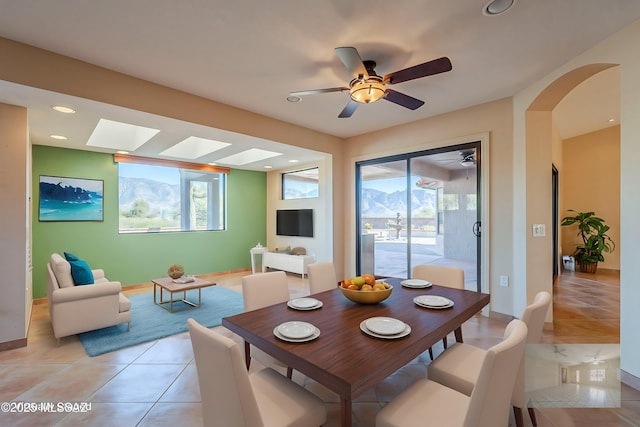 dining area featuring arched walkways, light tile patterned floors, recessed lighting, and a healthy amount of sunlight