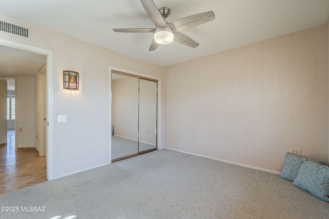 unfurnished bedroom featuring ceiling fan, visible vents, baseboards, a closet, and carpet