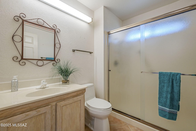 full bath featuring a stall shower, tile patterned flooring, vanity, and toilet