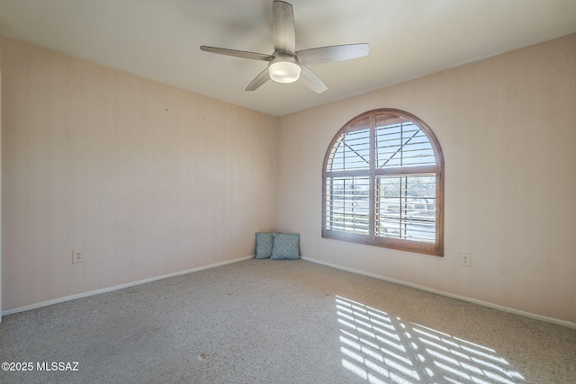 carpeted spare room with ceiling fan and baseboards