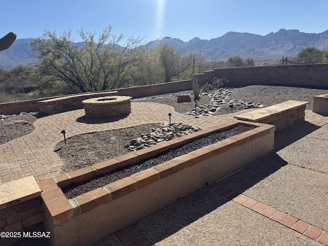 view of patio / terrace featuring a fire pit, a fenced backyard, and a mountain view