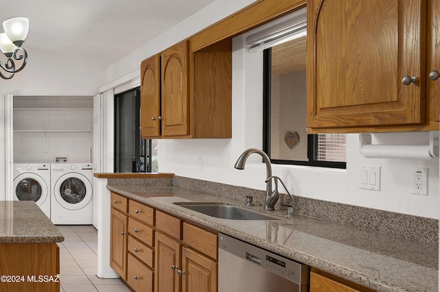 kitchen featuring a sink, brown cabinets, separate washer and dryer, and stainless steel dishwasher