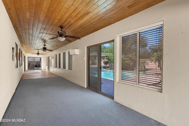 interior space with a ceiling fan and an AC wall unit