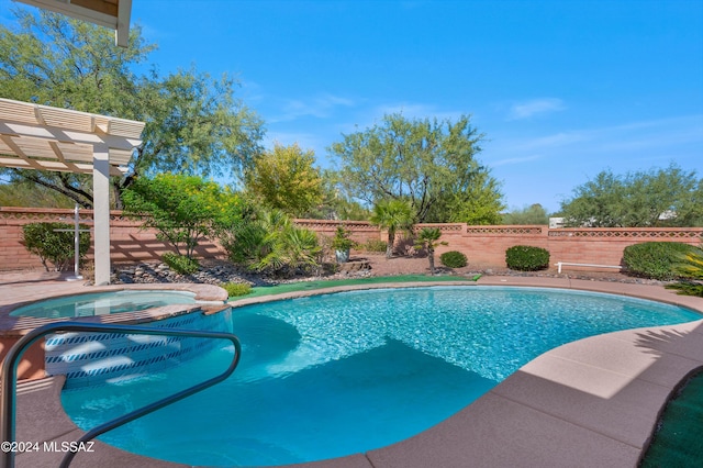 view of swimming pool with a fenced backyard, a pool with connected hot tub, and a pergola