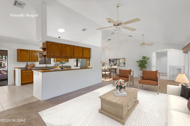 living area featuring light tile patterned floors, arched walkways, light carpet, visible vents, and vaulted ceiling