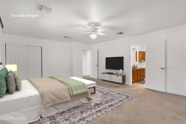 bedroom featuring a closet, visible vents, connected bathroom, and light carpet