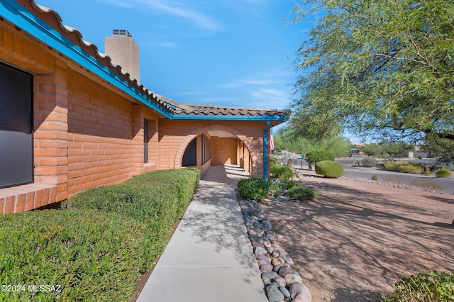 exterior space featuring brick siding and a chimney