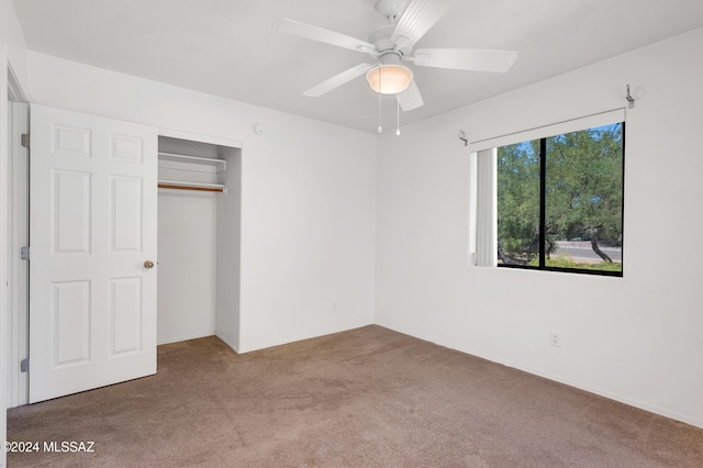 unfurnished bedroom with carpet floors, a closet, and a ceiling fan