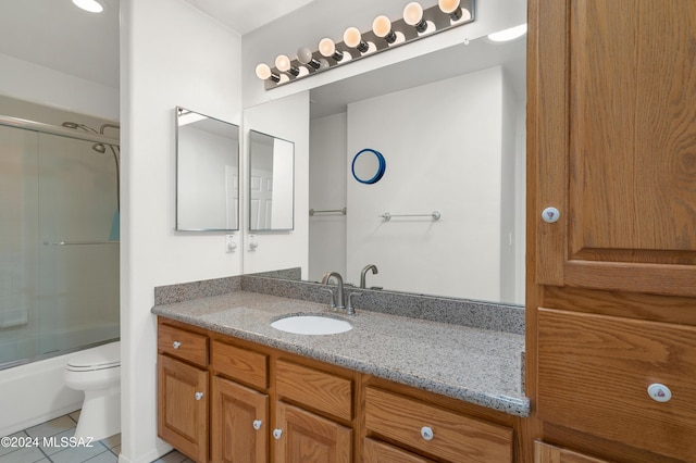 bathroom with vanity, bath / shower combo with glass door, tile patterned flooring, and toilet