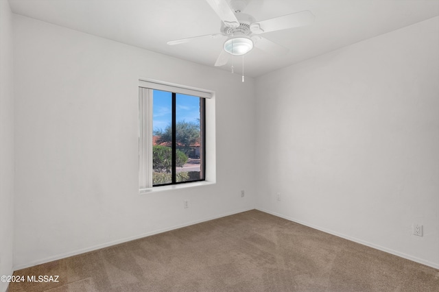 unfurnished room with carpet, a ceiling fan, and baseboards