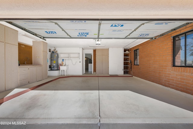 garage with gas water heater, a sink, and a garage door opener